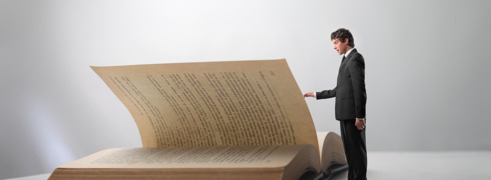 Kleiner Mann steht vor großem Buch