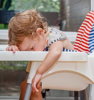 Baby mit dem Kopf auf dem Tisch