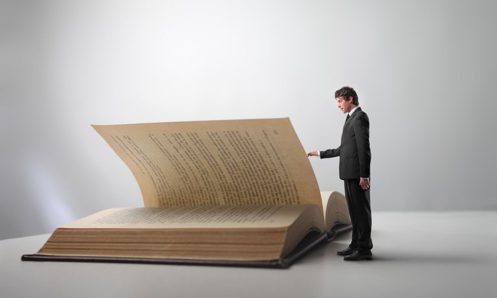 Kleiner Mann steht vor großem Buch