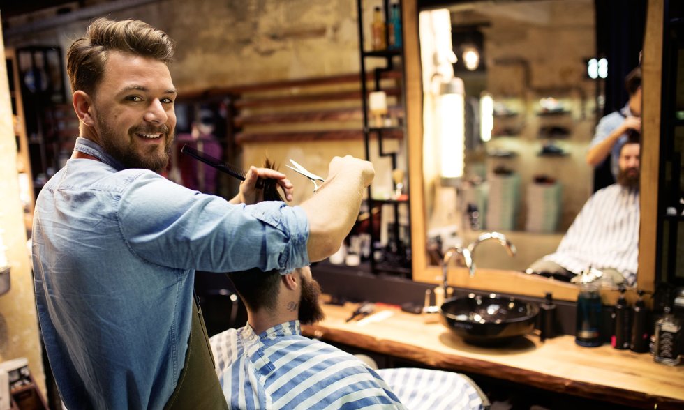 Friseur schneidet dem Klienten in einem Friseursalon die Haare