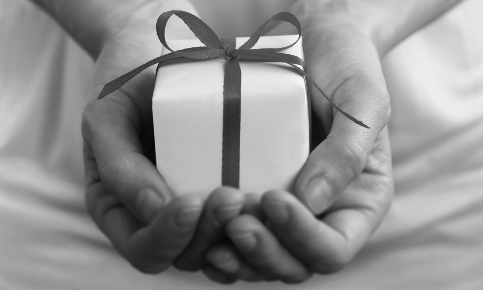 Ein kleines Geschenk wird mit beiden Händen gehalten